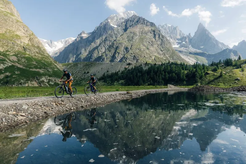 Two riders along an alpine lake below Mont Blanc