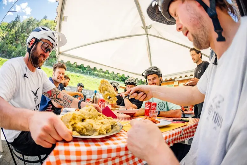 A group sharing a meal outdoors after a day on the bikes